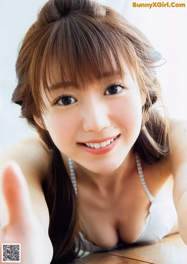 A young woman laying on top of a wooden table.