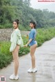 A couple of women standing next to each other on a road.