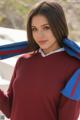 A woman in a red sweater and blue scarf posing for a picture.