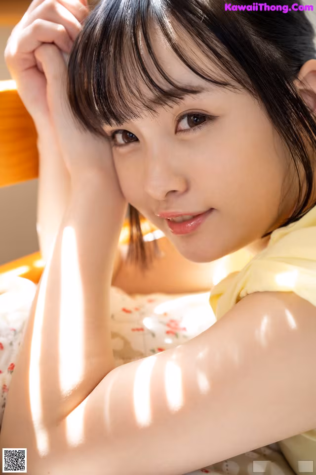A woman in a yellow dress laying on a bed.