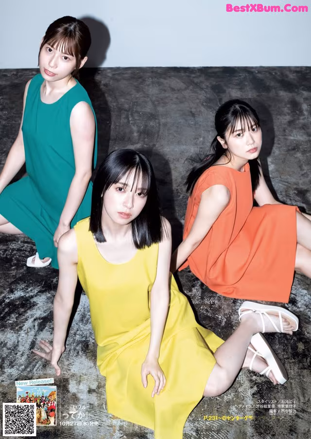 A group of three women sitting on the ground.