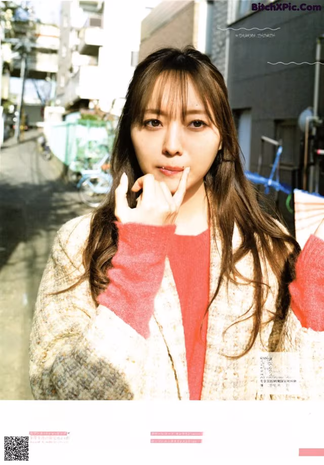 A woman in a red sweater is posing for a magazine.