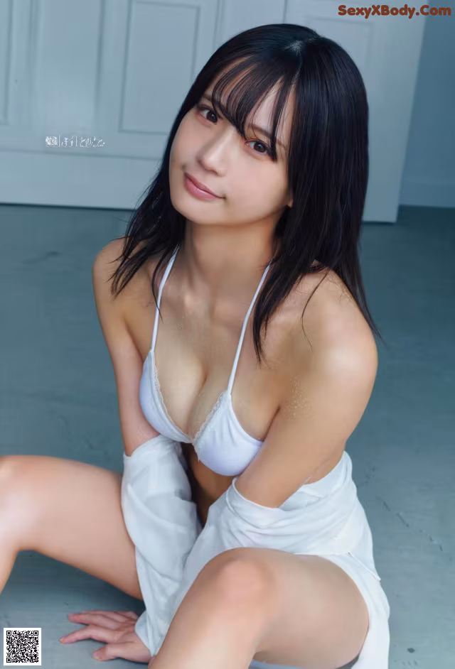 A woman in a white dress sitting on the floor.