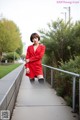 A woman in a red dress and black tights posing for a picture.