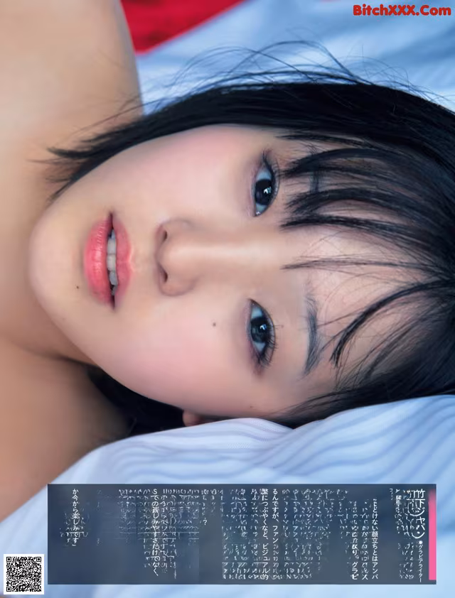A woman laying on top of a bed next to a pillow.