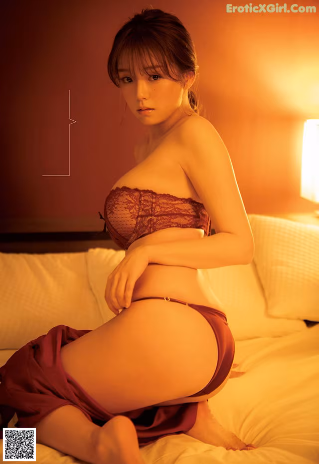 A woman in lingerie sitting on a bed.