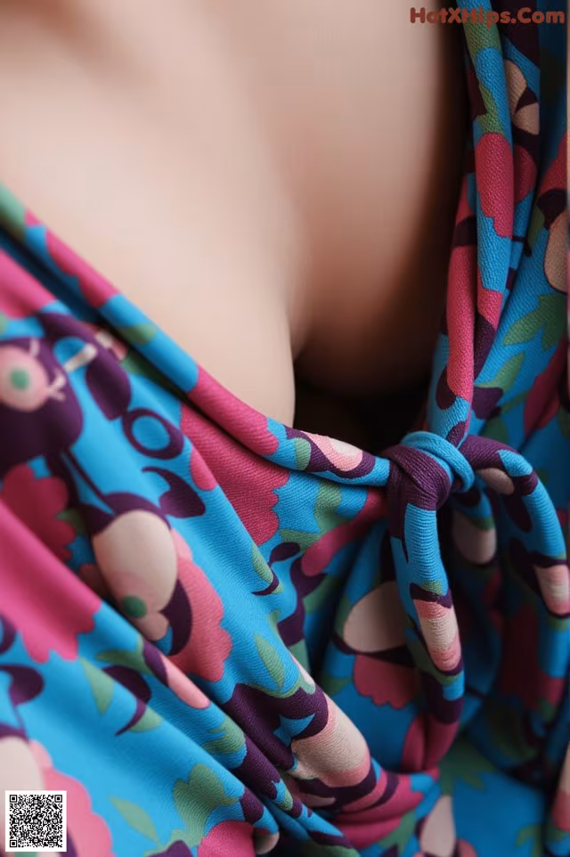 A close up of a woman wearing a blue and pink dress.
