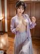 A woman in a purple kimono is posing for the camera.