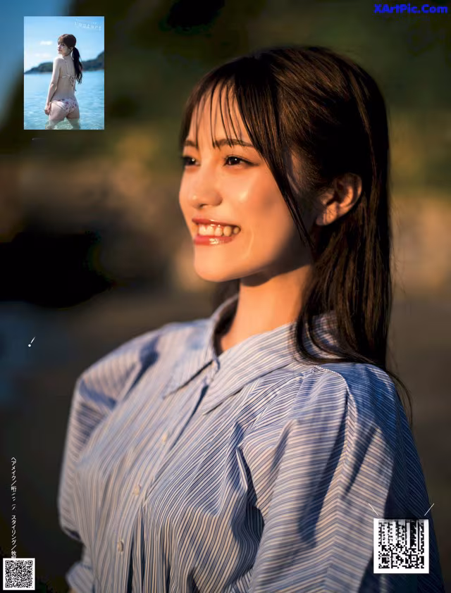 A woman in a blue and white striped shirt smiles at the camera.