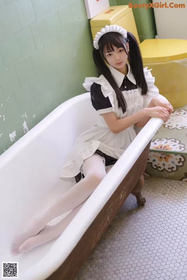 A woman sitting in a bathtub in a bathroom.