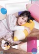 A woman laying on the floor next to a bunch of pillows.